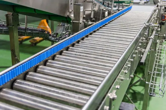 Stainless steel roller conveyor with a blue modular chain running alongside